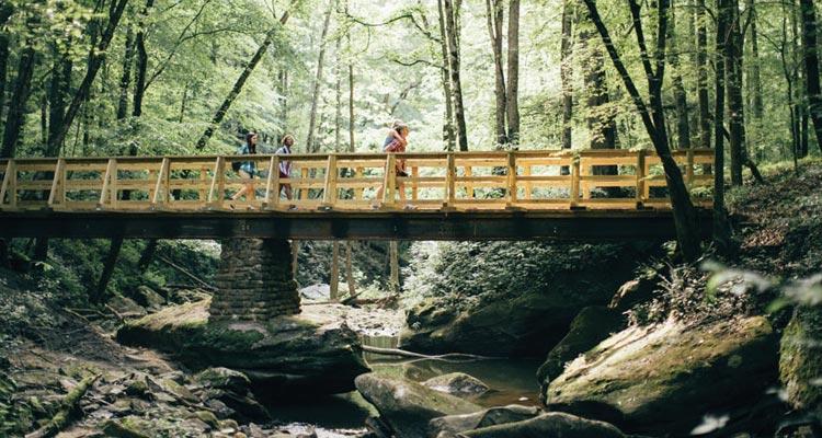 Image of hikers going across a bridge